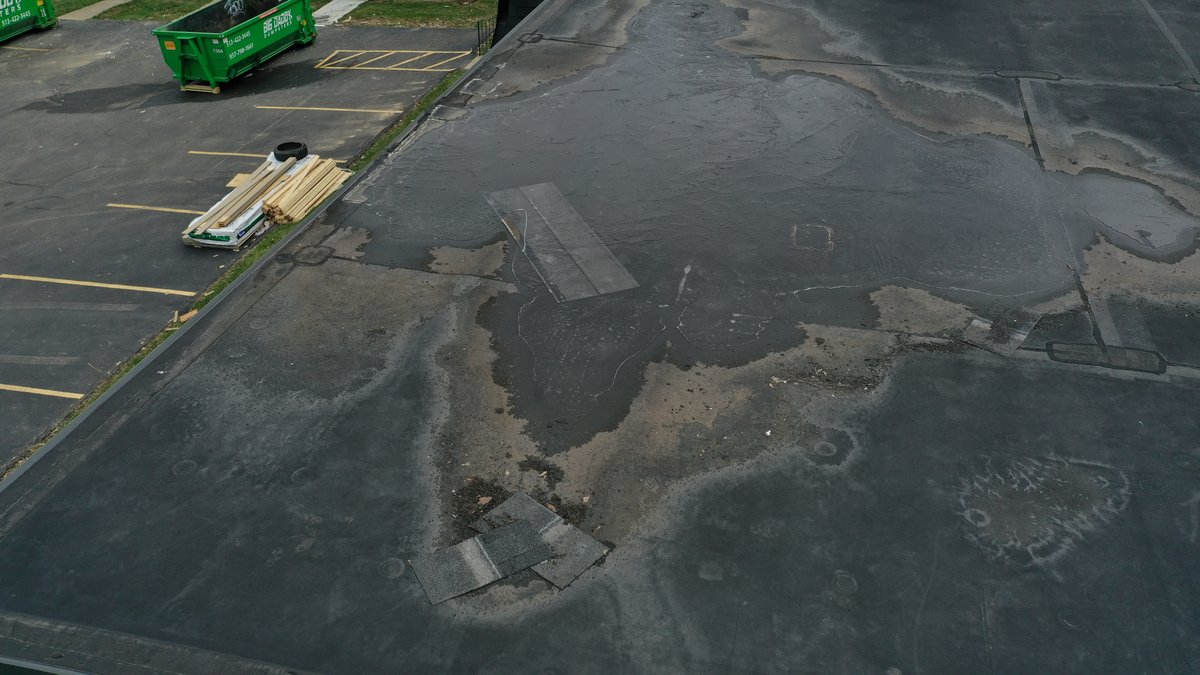 Drone view showing roof damage and construction materials