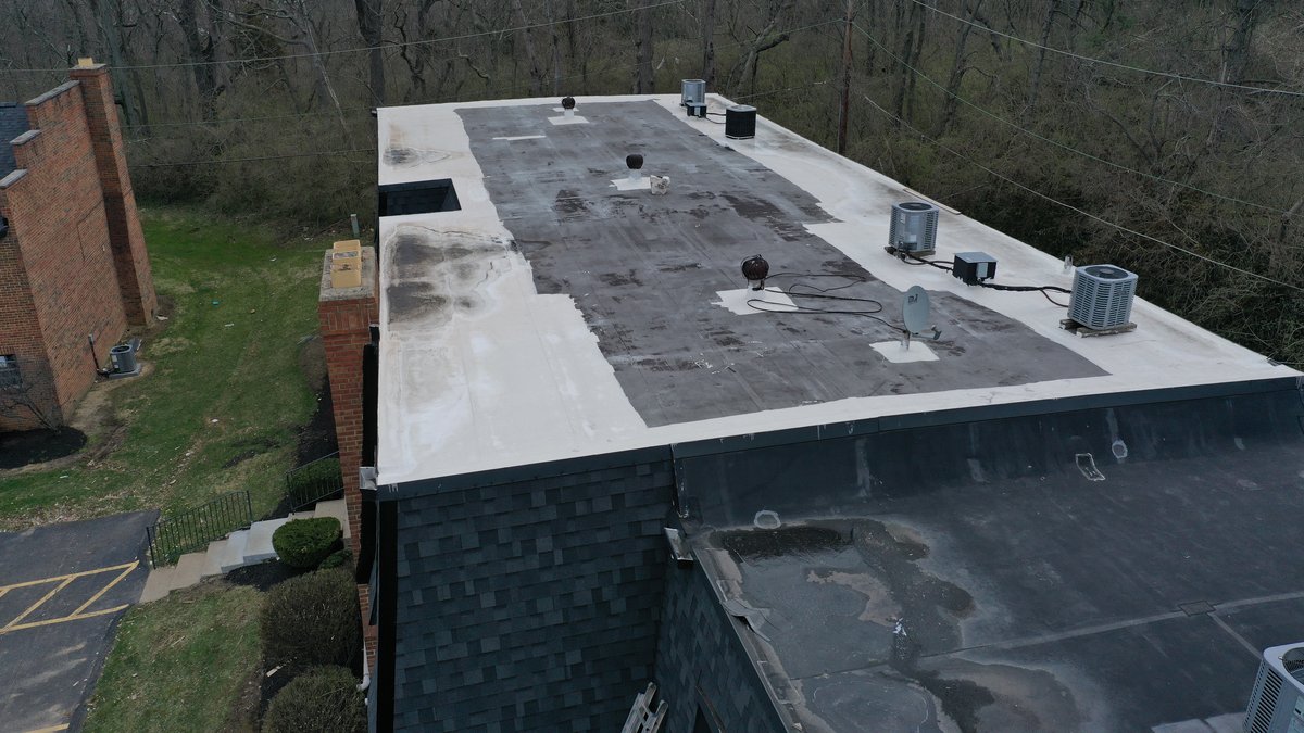 Drone view of building with new shingle siding